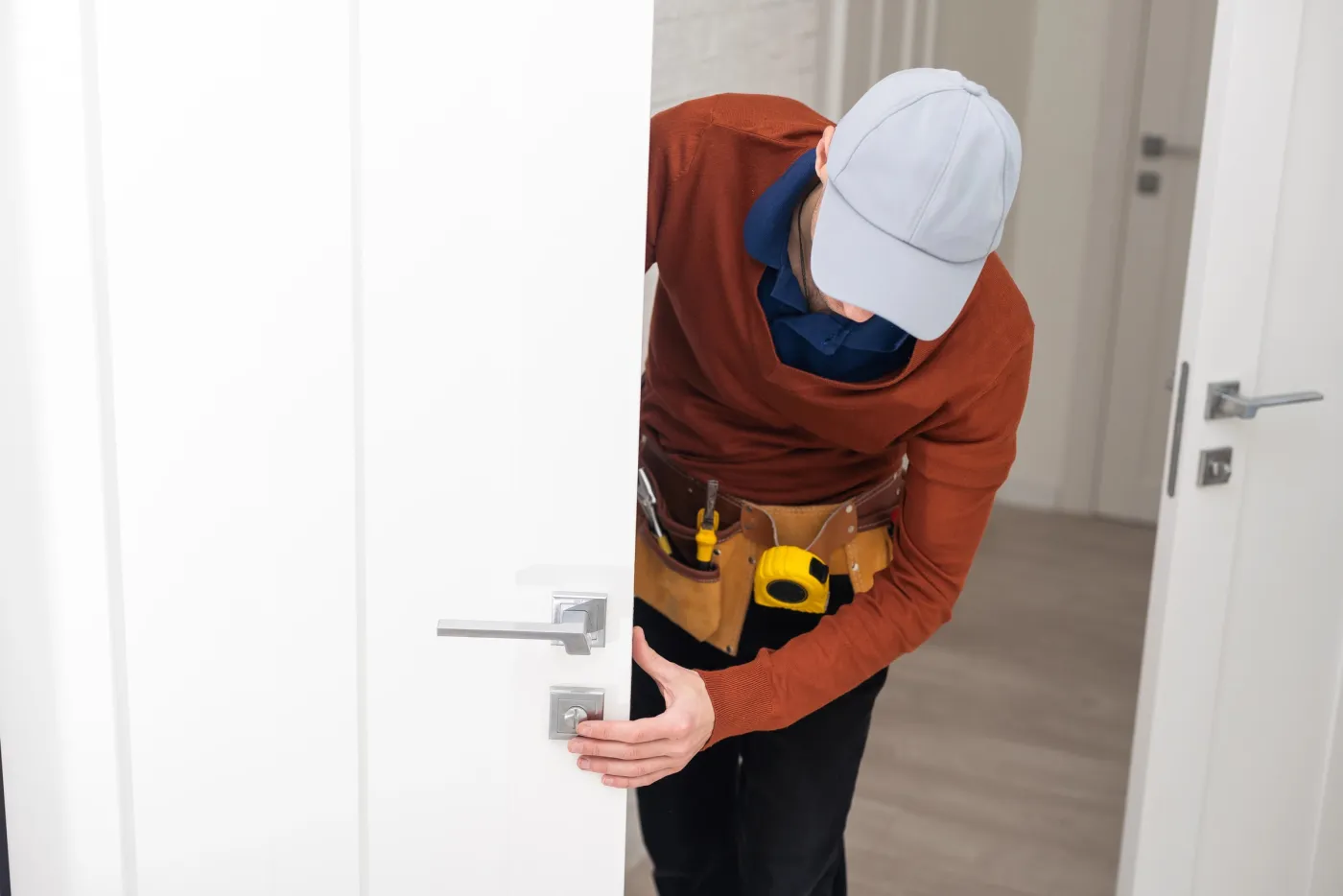 Artisan serrurier posant une poignée et une serrure sur une porte de pavillon à Gargenville